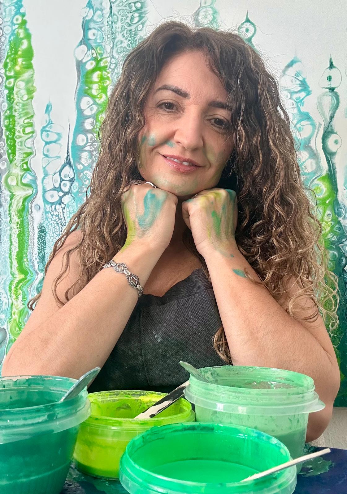 Chelo González en su estudio con manos manchadas de pintura